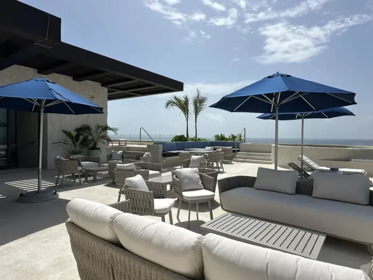 Terraza lounge de Sole BLU con salas exteriores, sombrillas azules y vista al mar